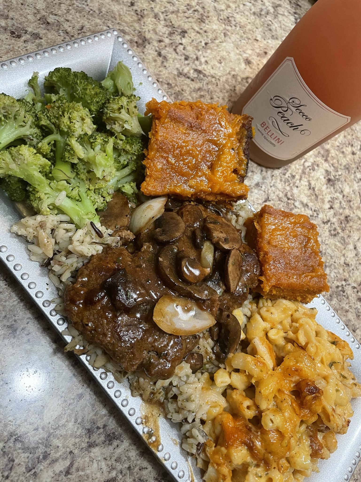 Hamburger steak smothered in gravy , over a bed of wild rice  , macaroni and cheese & steamed broccoli 🥦 with a side of sweet potato cornbread 🫶🏾