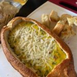 Homemade spinach artichoke dip in a Rosemary bread