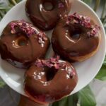 Homemade yeast donuts with chocolate glaze and organic roses