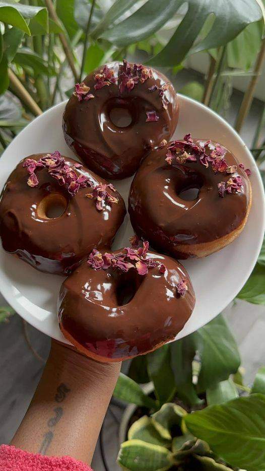 Homemade yeast donuts with chocolate glaze and organic roses